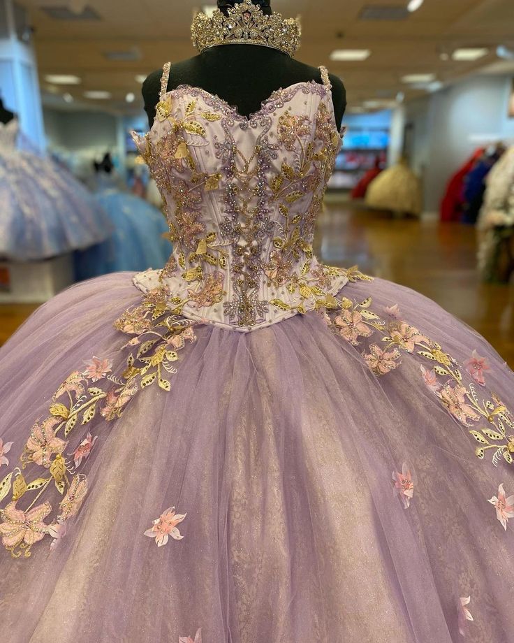 a dress with flowers on the skirt and a tiara is displayed in a store