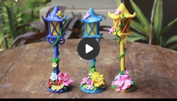 three colorful candles sitting on top of a wooden table