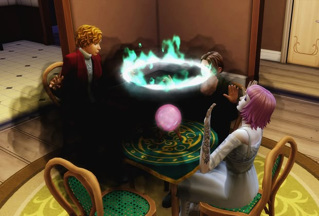 two people sitting at a table in front of a fire ring on the table and another person standing next to them