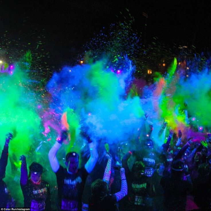 people are throwing colored powder on each other in the air at an outdoor event,