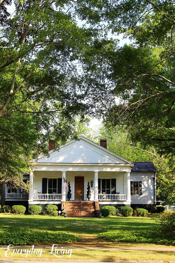 a white house surrounded by trees and grass