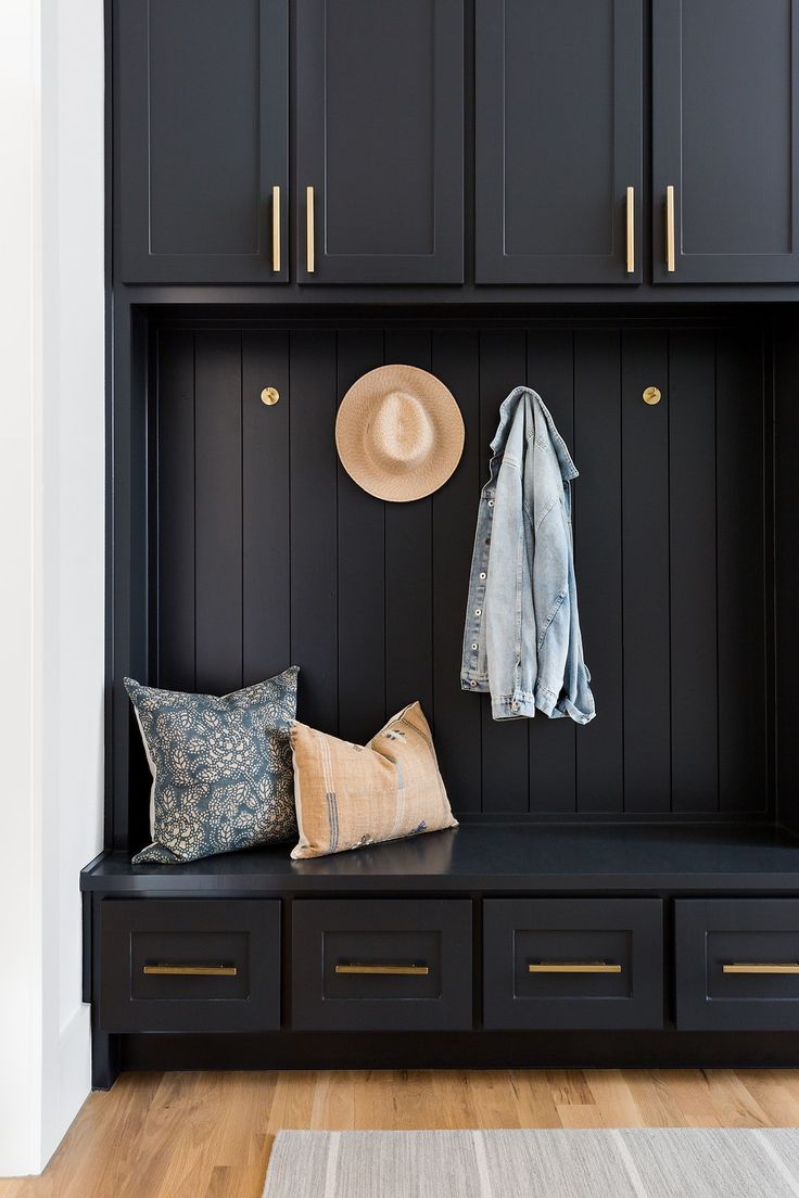 a black bench with some pillows and hats on it