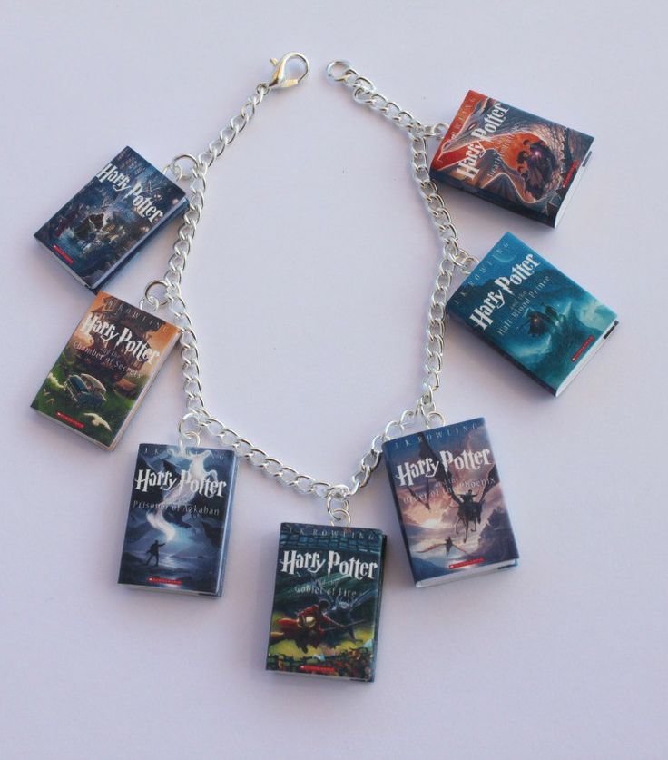 a harry potter book bracelet is shown on a white surface, with seven books attached to it