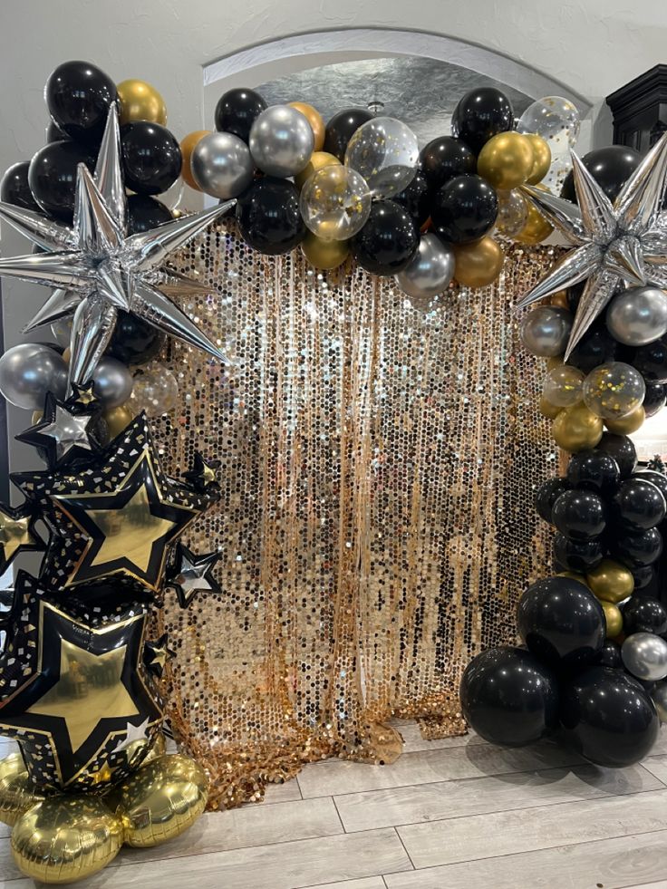 black, gold and silver balloon arch with stars