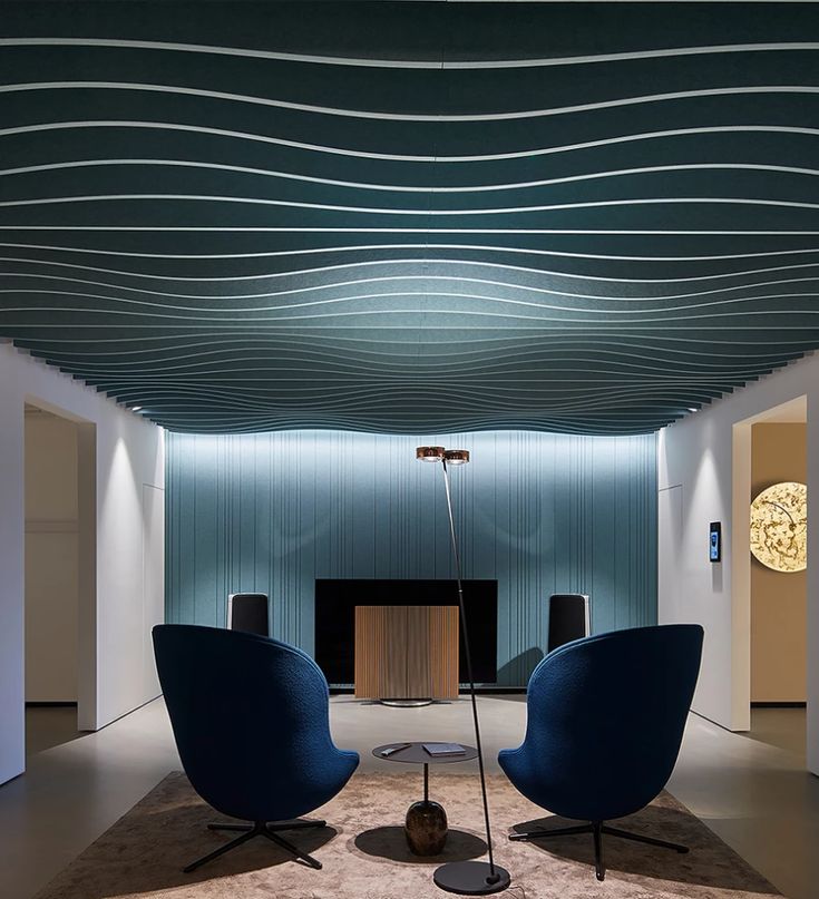 two blue chairs sitting on top of a carpet covered floor