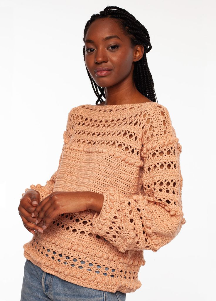 a woman is posing for the camera wearing a sweater with crochet on it