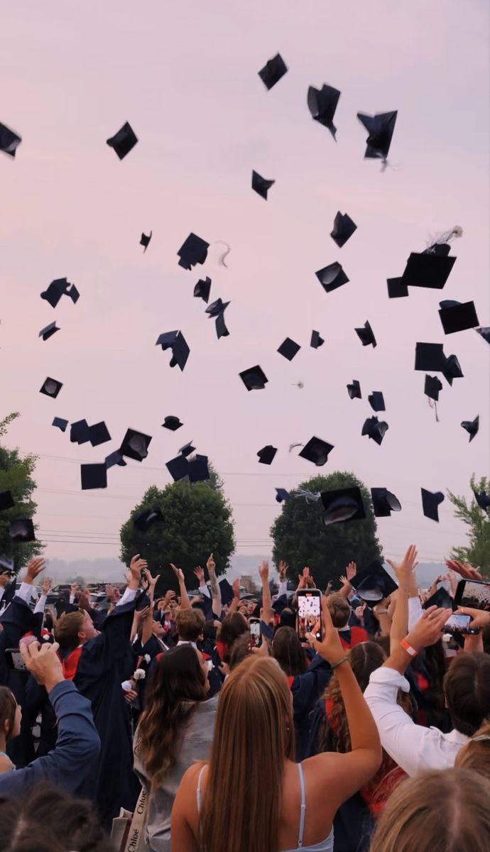 a group of graduates throwing their caps in the air