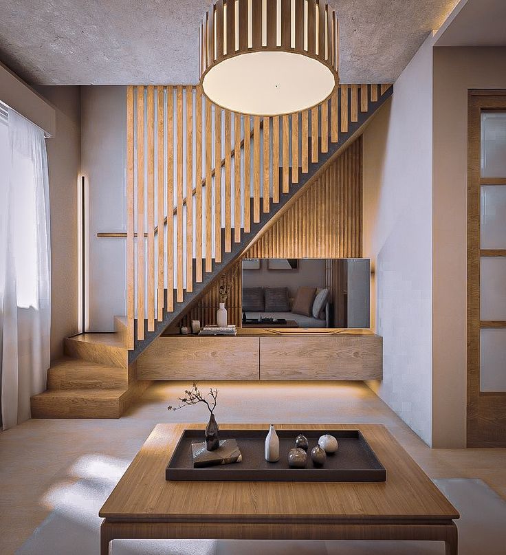 a living room filled with furniture and a wooden staircase leading up to the second floor