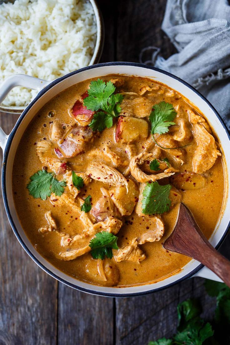 a bowl filled with chicken curry and garnished with cilantro