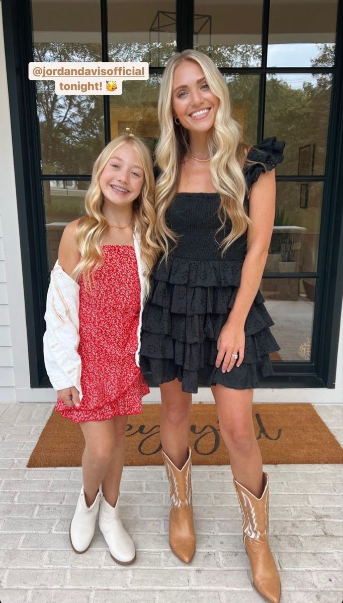 two girls are standing in front of a door wearing cowboy boots and dresses with ruffles on them