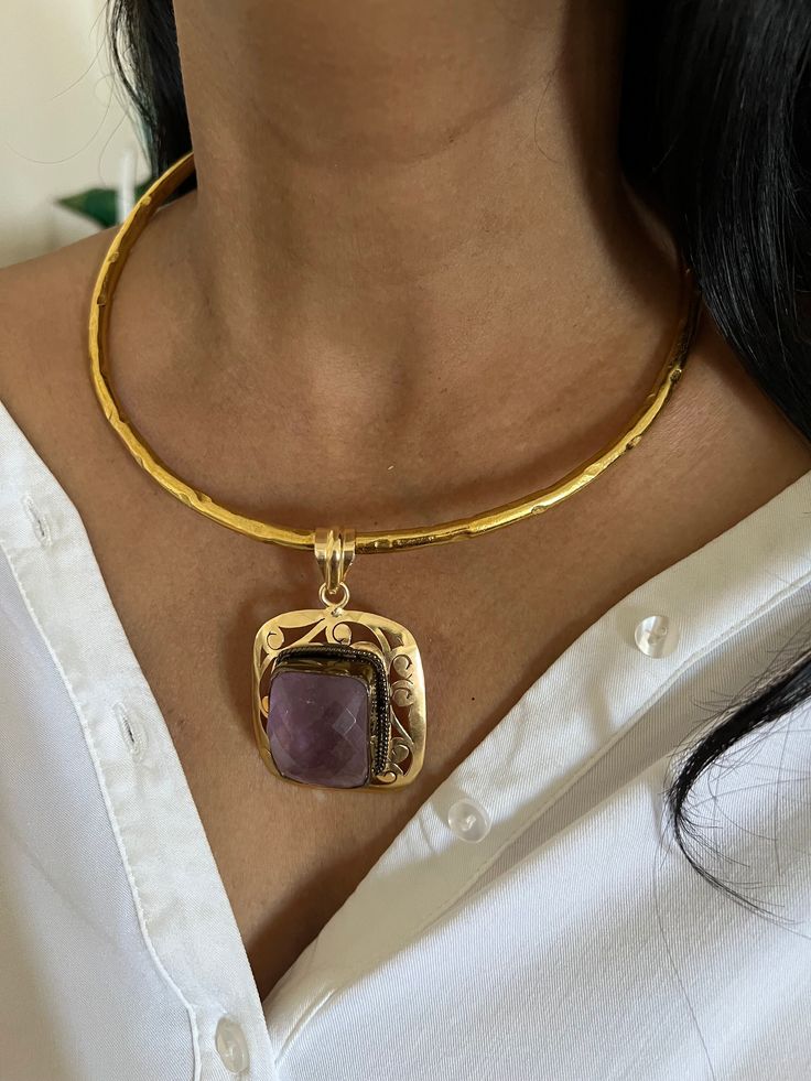 NEW ARRIVAL ♥️ One of a kind designer piece by Shivka! Purely handmade with love by our skilled Indian craftsmen from Jaipur  Material: Brass with gold plating Premium Quality Height of Pendant: 5.5 cm. Width of Pendant: 4.5 cm. Weight of the Pendant: 26 grams. Weight of Hasli: 60 grams. Material: Brass and Rose Amethyst  Note: The Hasli necklace and the pendant are detachable and can be worn separately. Pick it up and make a stunning statement at the next event Handmade Yellow Gold Festive Jewelry, Festive Artisan Necklace For Gift, Traditional Gold Hammered Jewelry, Traditional Hammered Gold Jewelry, Artisan Gold Necklaces For Anniversary, Handmade Gold Temple Jewelry, Artisan Gold Necklace For Formal Occasions, Artisan Gold Jewelry For Gifts, Gold Gemstone Jewelry For Celebration