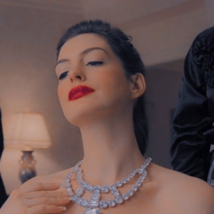 a mannequin wearing a diamond necklace and red lipstick in front of a man