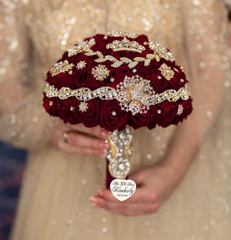 a bridal holding a bouquet of red roses and brooches in her hands