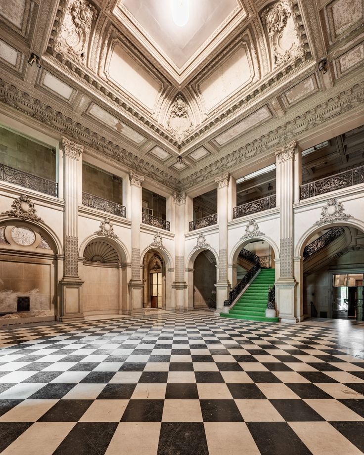 an empty room with checkered floor and stairs