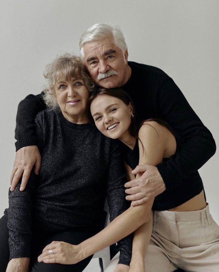 an older man and two younger women hugging each other