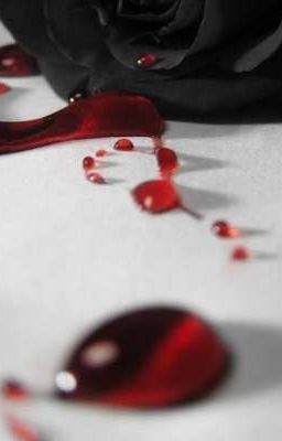 the rose is laying on the table with blood running down it's petals and water droplets