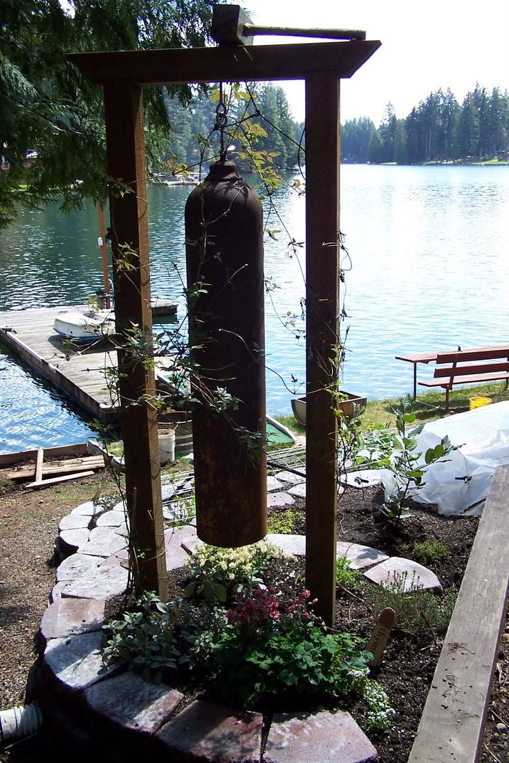 an outdoor area with rocks, plants and a fire hydrant near the water's edge