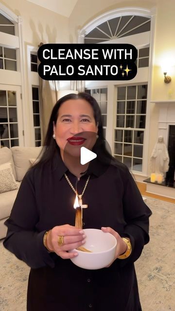 a woman holding a white bowl with a candle in it and the caption cleanse with palo santo