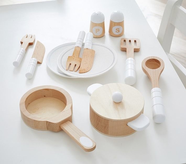 wooden kitchen utensils are arranged on a white table