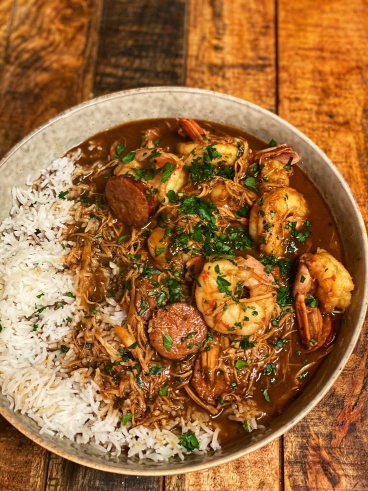 a bowl filled with shrimp and rice on top of a wooden table