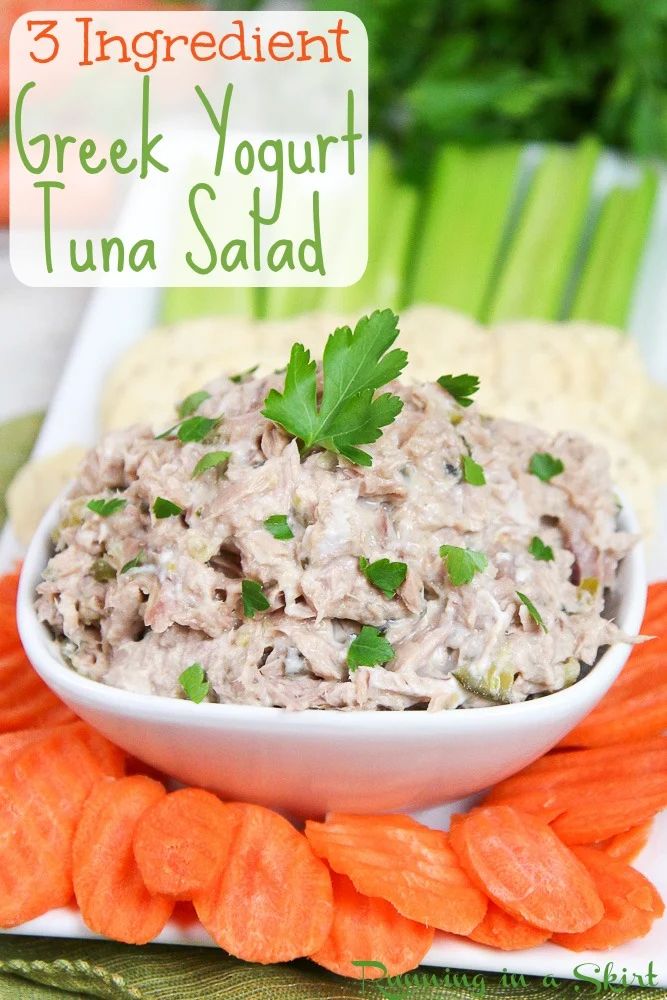 there is a bowl of tuna salad with carrots and celery on the side