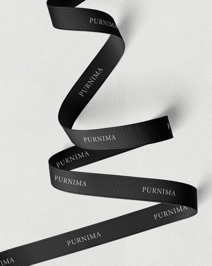 three black ribbons with the words purimma printed on them are flying in the air