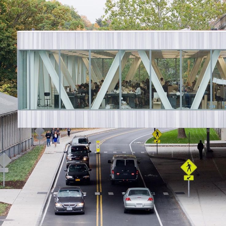 cars are driving on the road under a bridge with people eating and drinking in it