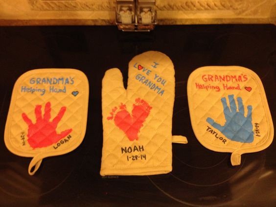 three oven mitts with handprints on them and the words grandma's helping hand