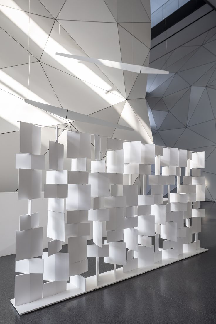 an abstractly designed room with white walls and ceiling tiles in the shape of rectangles