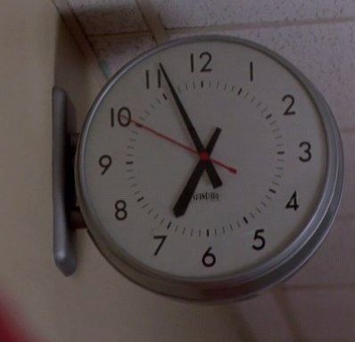 a clock hanging on the wall with red and white numbers in it's hands