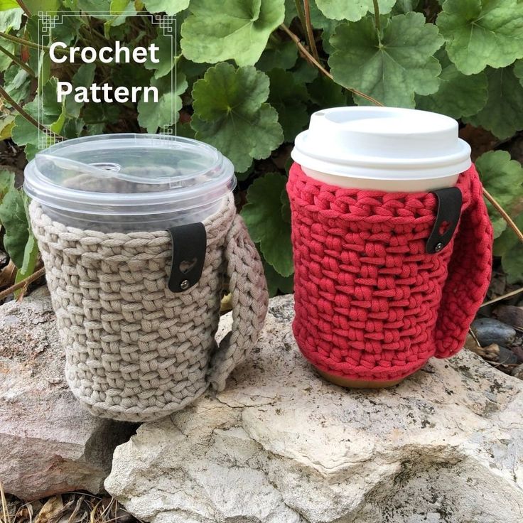 two crocheted coffee cups sitting on top of a rock