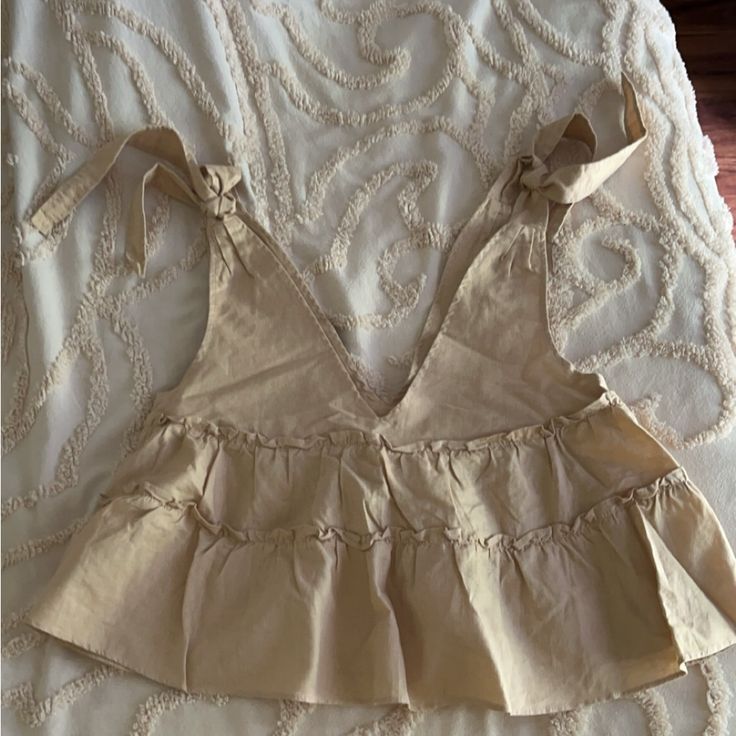 Brand New Never Worn. Petal & Pup Cream Colored, Low Cut, Very Flowery Top. The Ties At The Top Are Adjustable. It Is Very, Very Roomy. Beige Sleeveless Top With Tie Back, Beige Tie Back Tops For Beach, Beige Tie Back Tops For The Beach, Sleeveless Beige Top With Tie Back, Cute Beige Summer Tops, Beige Ruffled Summer Tops, Chic Beige Tops With Tie Back, Chic Beige Tie-back Top, Chic Beige Tie Back Top