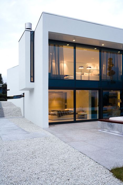 a modern house with large glass windows on the outside and stairs leading up to it