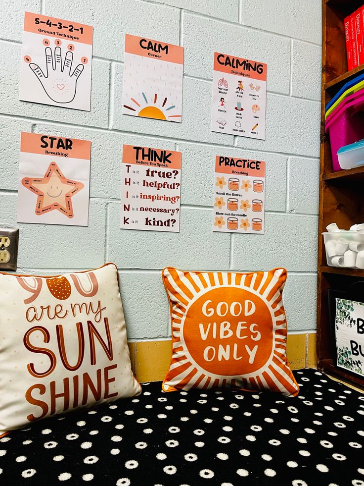 some pillows are sitting on a bed in front of a wall with pictures and words