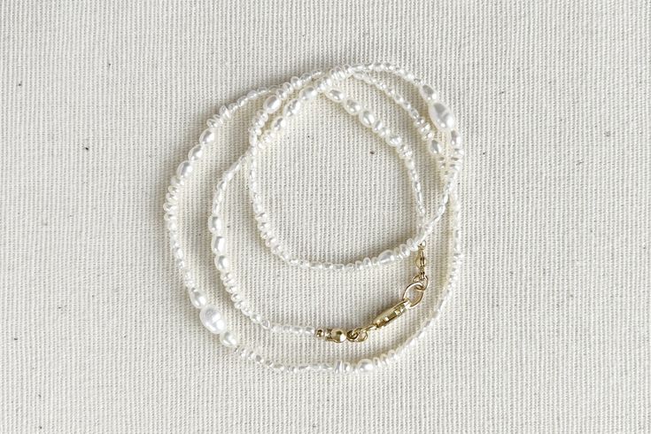 It isn't perfection, but our unique individualism, that gives us all beauty. Meet Esme, a delicate strand of multi-shapes and varying sizes of pearls strung together with artful beauty in mind. Dainty and sweet, perfect for any occasion. DETAILS Pearl diameter 1.5mm-5.5mm * Genuine freshwater pearls * 14k gold-filled | Sterling silver * Silk string * Handcrafted with love & care * Special order item * Complimentary gift wrapping service (See FAQ for details) SPECIAL ORDER ITEM Please note that e Elegant Everyday Beaded Pearl Necklace, Minimalist Single Strand Pearl Beaded Necklace, Elegant Everyday Hand-strung Necklaces, Elegant Everyday Pearl Beaded Necklaces, Pearl White Jewelry With Tiny Beads, Pearl White Pearl Jewelry With Tiny Beads, Elegant Handmade Beaded Necklaces, Delicate Adjustable Pearl Necklace With Tiny Beads, Elegant Adjustable Pearl Necklace With Tiny Beads