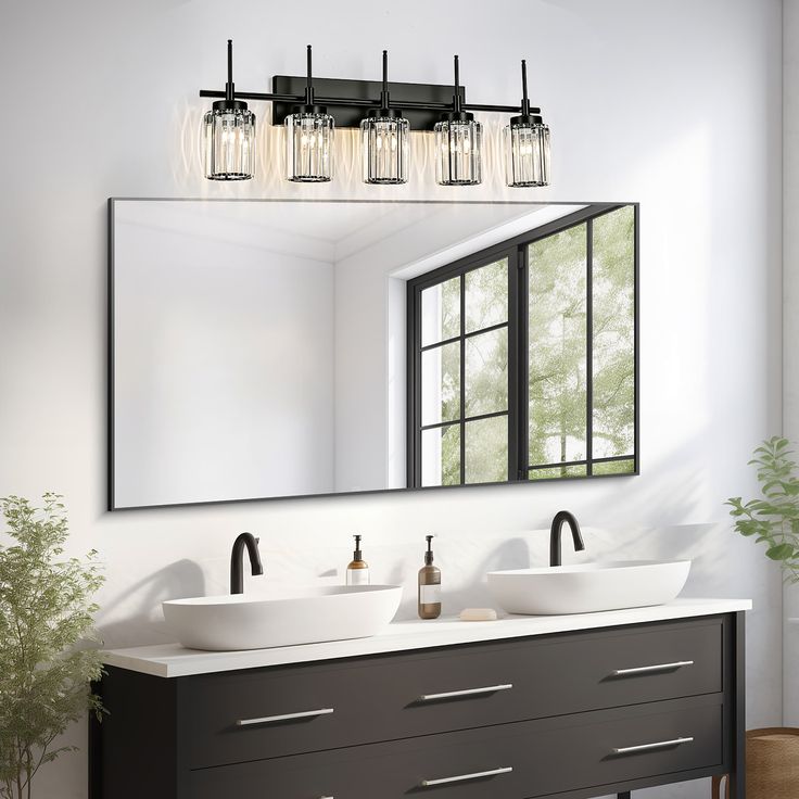 a bathroom vanity with two sinks under a large mirror and lights hanging above the sink