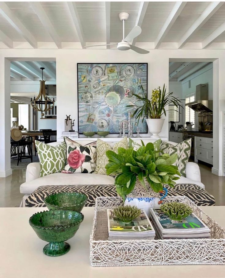 a living room filled with lots of furniture and plants on top of a coffee table