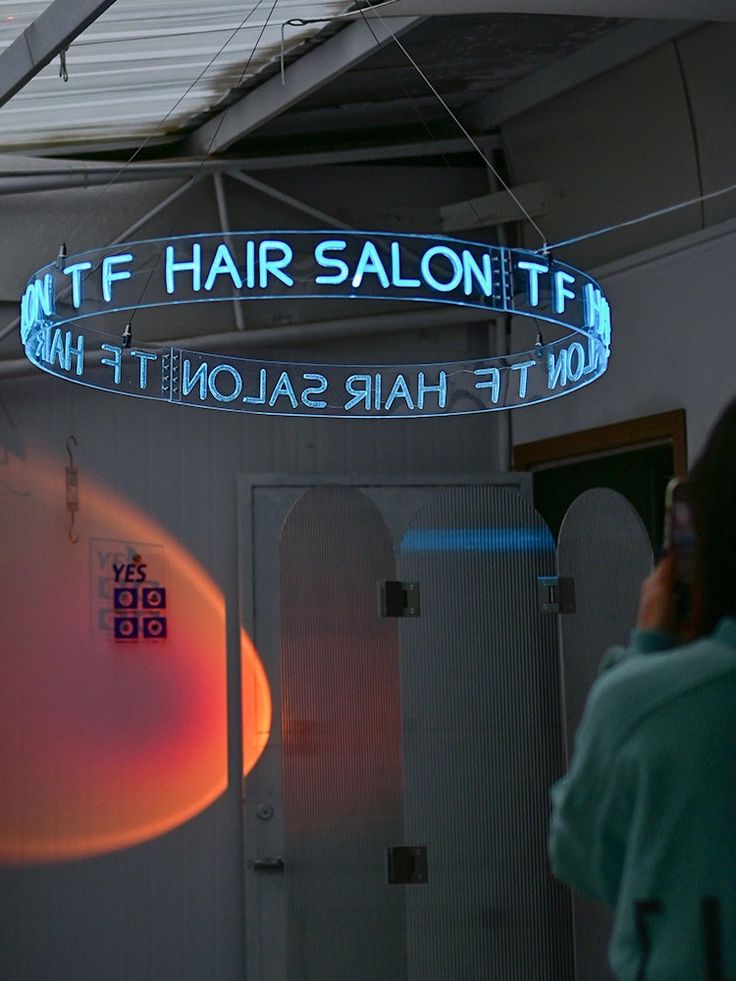 a woman is talking on her cell phone while standing in front of a hair salon