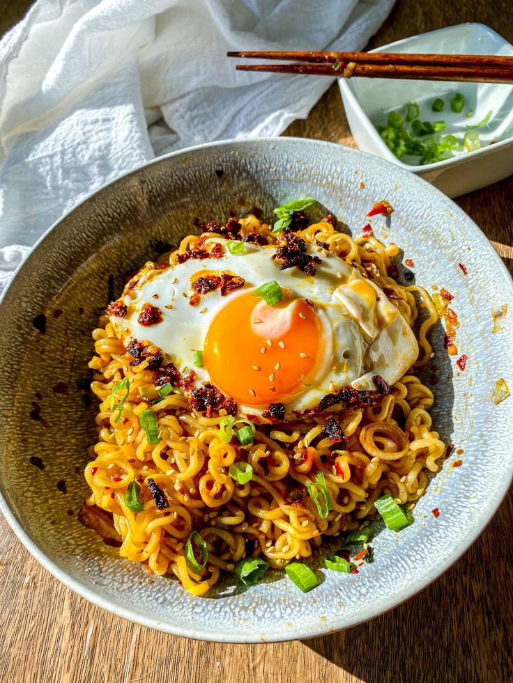 a bowl filled with noodles and an egg on top