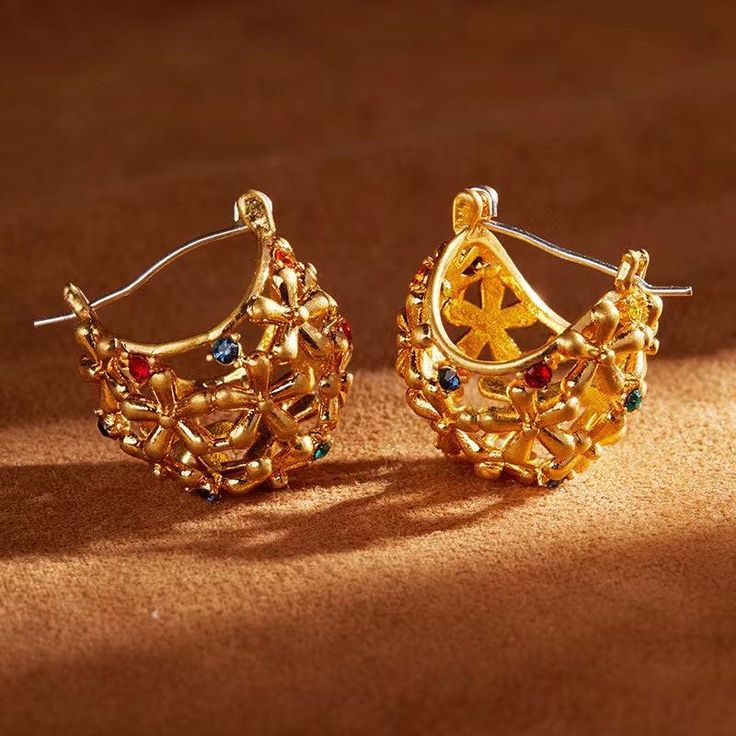 The sparkling zircon gem and intricate flower design, combined with the luxurious 18K gold plating, make these earrings a statement piece. Elevate your style with these beautiful and elegant earrings. Materials: A thick 18K gold layer on brass. All ear posts are made of 925 sterling silver . Weight: 0.4oz (total) Gem stone: Zircon Size: 0.75 inch x 0.75 inch approx (each)   Care This piece should be stored in a cool, dry place and cleaned carefully with a soft non-abrasive cloth to maintain shine. Flower Hoop Earrings, Gem Stone, Elegant Earrings, Flower Design, Flower Designs, Etsy Earrings, 18k Gold, Gold Plate, Hoop Earrings