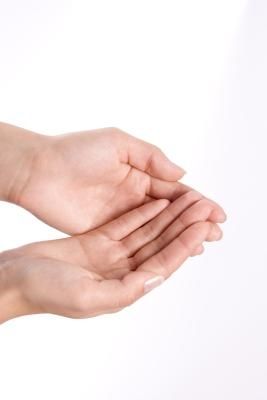 two hands are holding something in each other's palm, on a white background