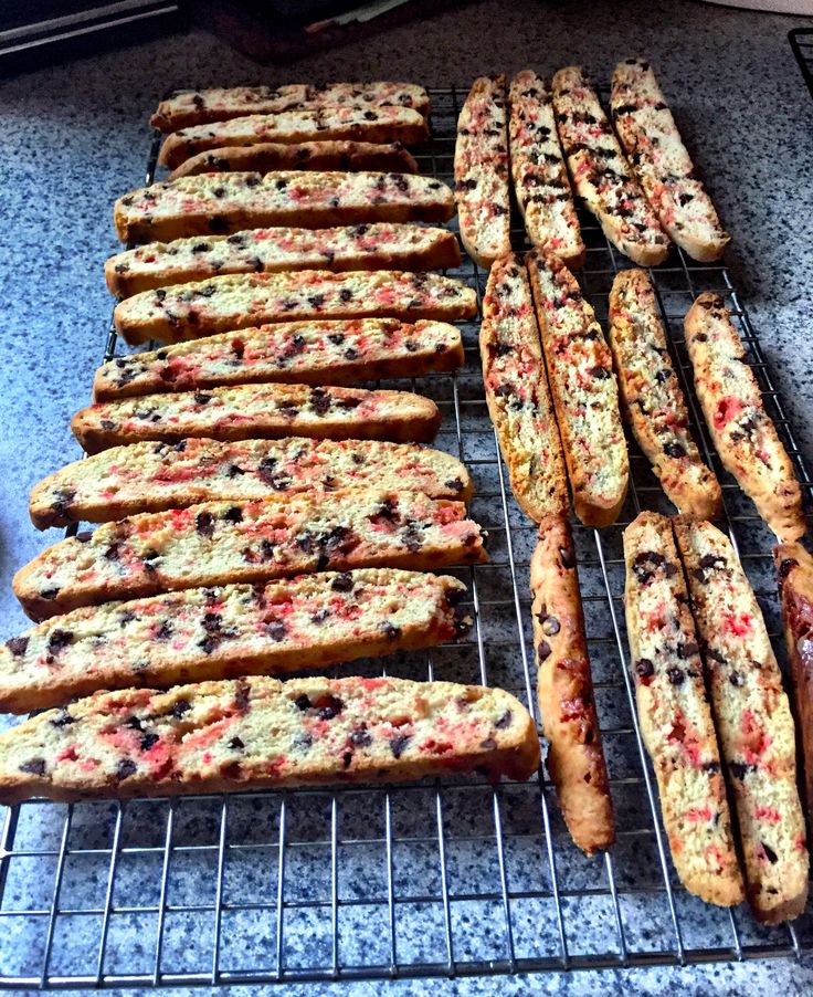 bread sticks lined up next to each other on a wire rack in front of an oven