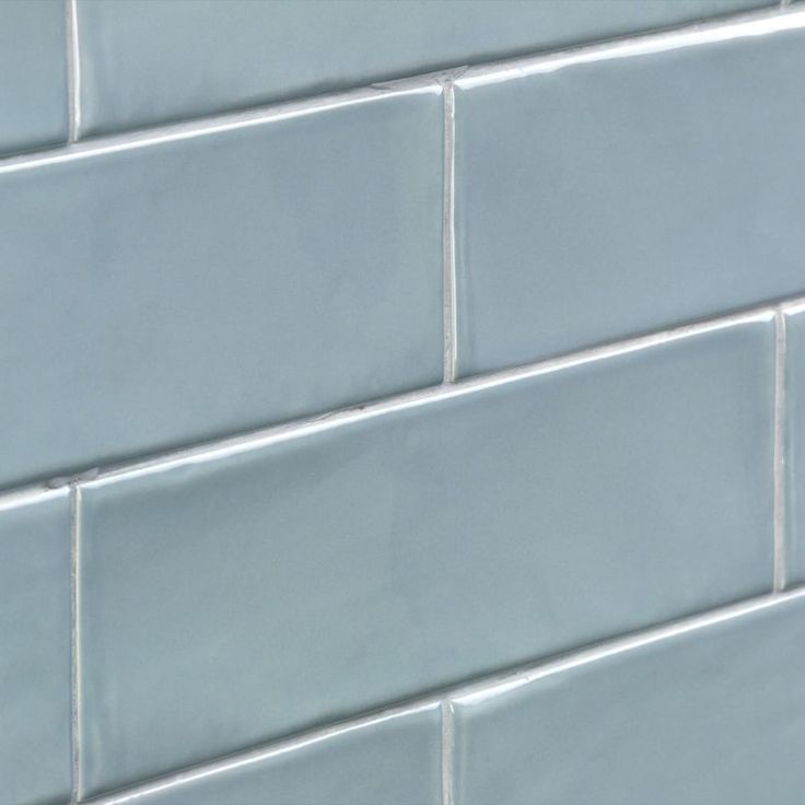 a close up view of a light blue tile wall