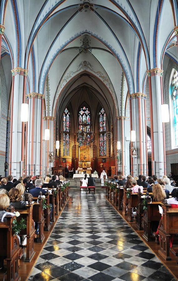 people are sitting in pews at the alter of a church with stained glass windows