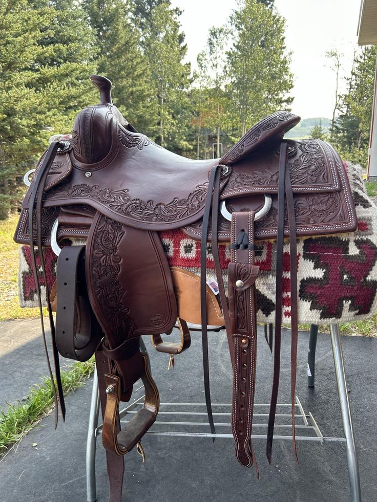 a brown saddle sitting on top of a metal stand