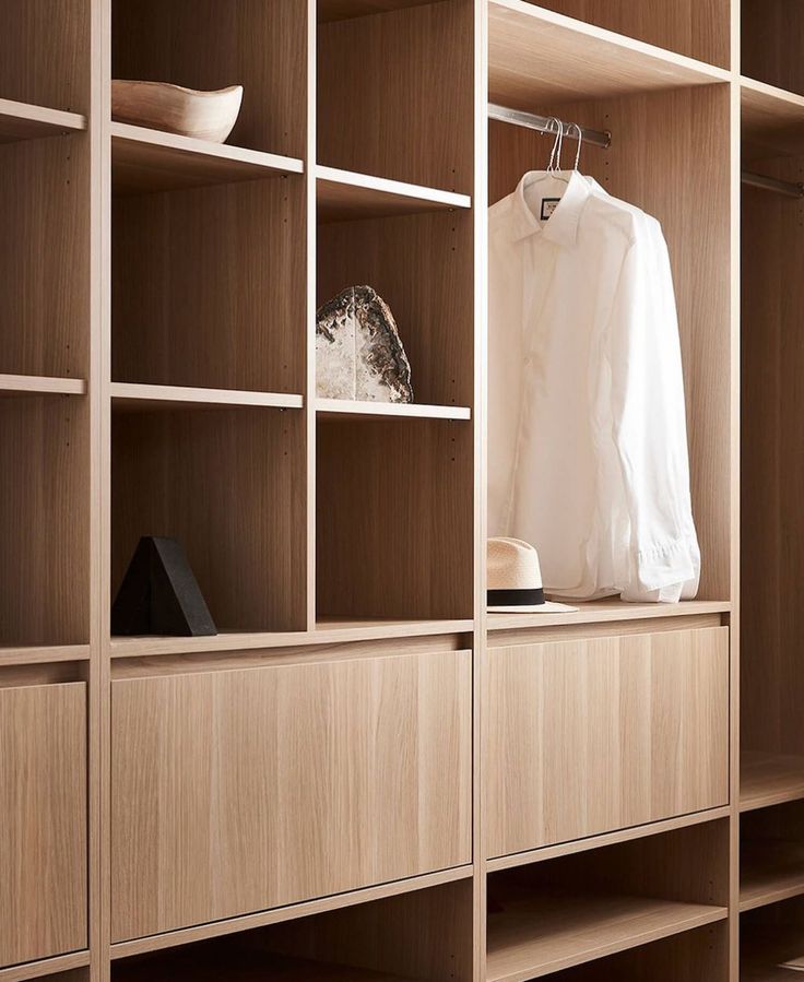 a white shirt hanging on a wooden shelf in a room with shelving and shelves