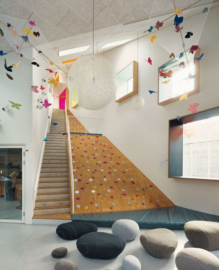 a room with many rocks and paper butterflies on the wall, along with a staircase