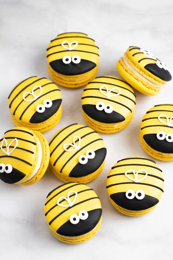 there are many decorated cookies with eyes and noses on the top one is made to look like a bee