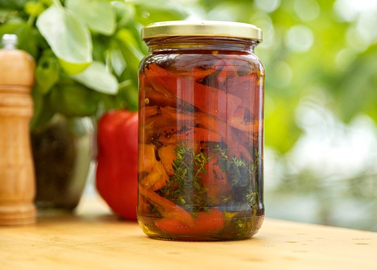 a jar filled with lots of vegetables sitting on top of a table