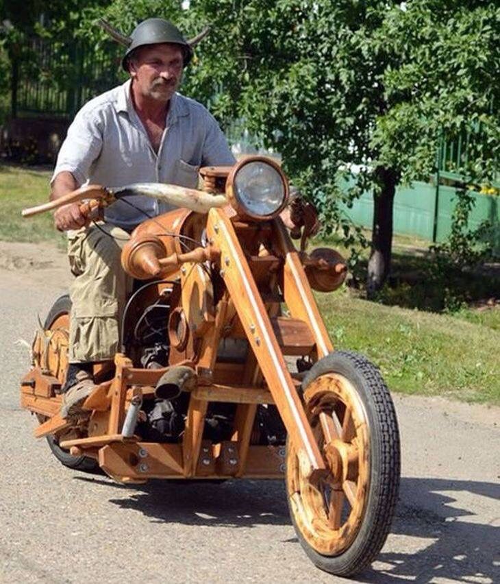 a man riding on the back of a wooden motorcycle